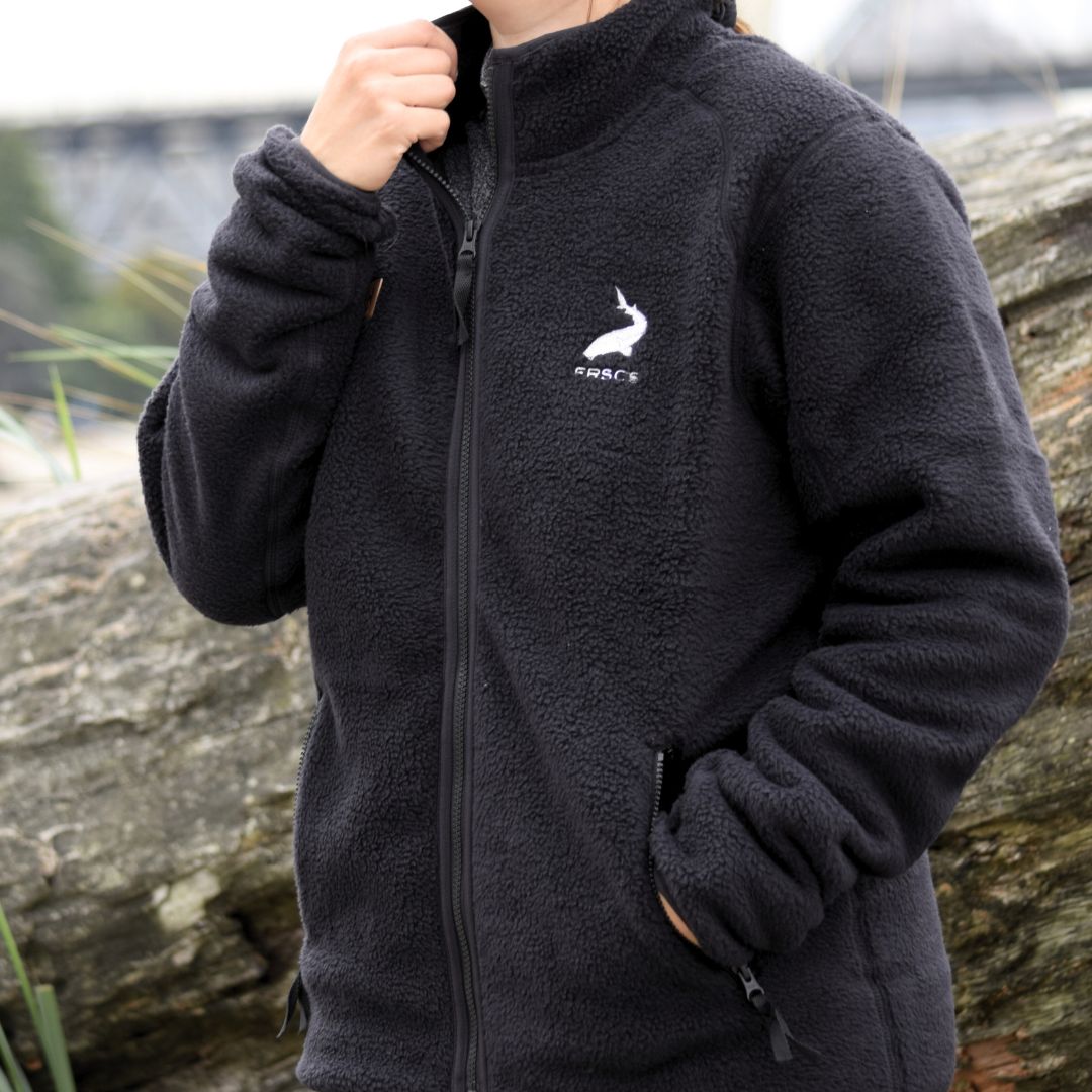Black Helly Hansen Heritage Pile Full Zip, with the model holding the collar, looking up and smiling