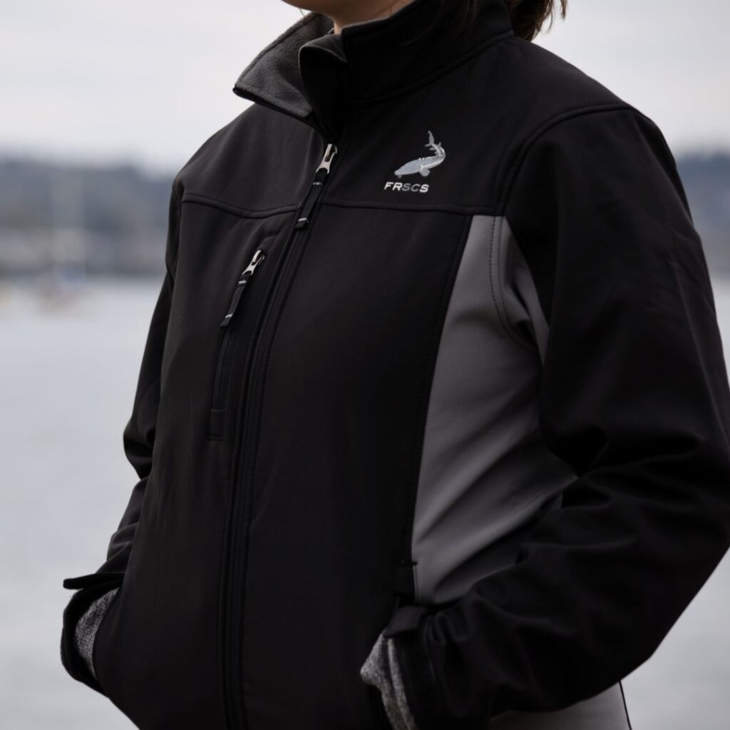 Close up shot of the black and grey Men's Polar Tech Jacket, with the FRSCS Logo on the left chest. Side view.